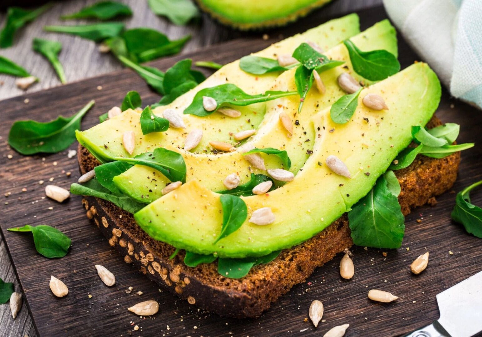 A sandwich with avocado and nuts on top of it.